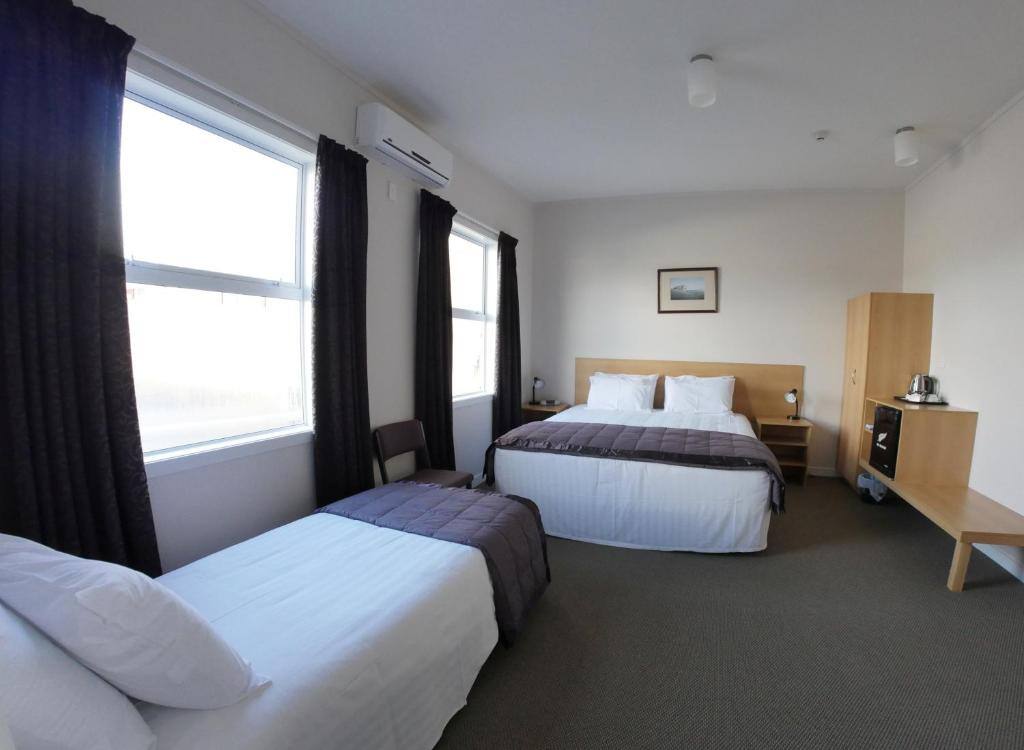 Spacious room with two beds and tall windows